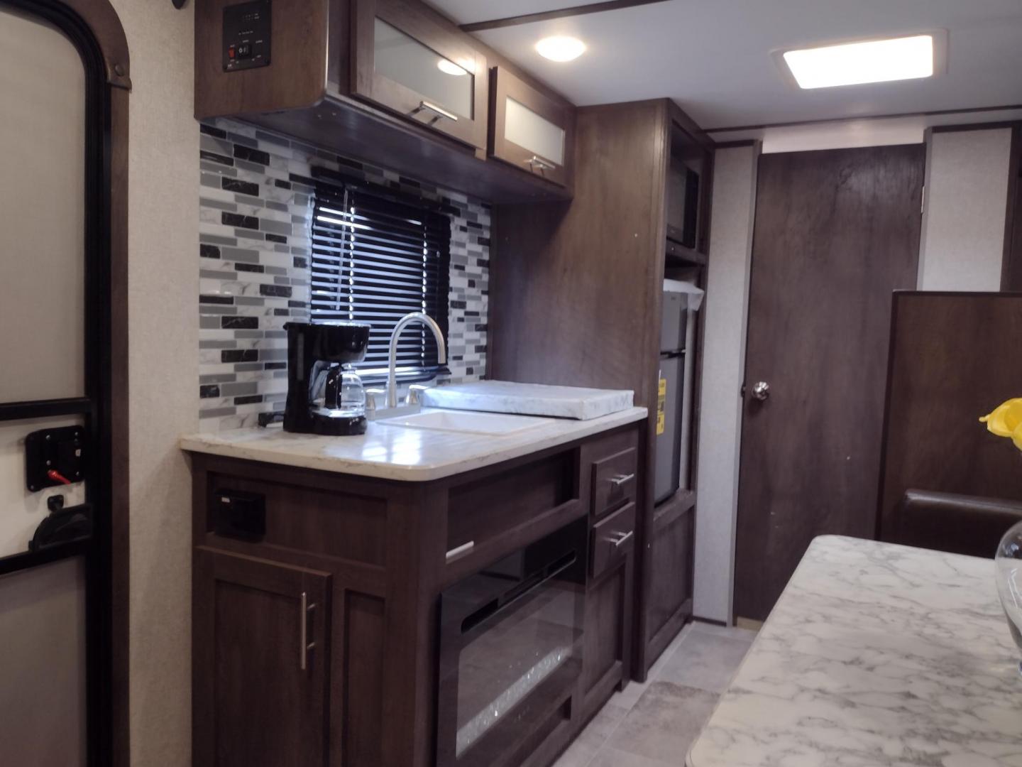 2022 WHITE /TAN Keystone COLEMAN 17B 17B (4YDTCMG17NJ) , located at 17760 Hwy 62, Morris, OK, 74445, 35.609104, -95.877060 - CHECK OUT THIS 2022 KEYSTONE COLEMAN DUTCHMEN 17B 21FT OVERALL WITH 8FT POWER AWNING. HAS QUEEN SIZE BED WITH OVERHEAD SHELF AND STORAGE UNDER BED. IN THE LIVING AND KITCHEN AREA IS A L-SHAPED DINETTE WITH STORAGE UNDER SEATS, OVERHEAD CABINETS, SINGLE SINK, 2 BURNER STOVE (NO OVEN), OVERHEAD CABIN - Photo#7